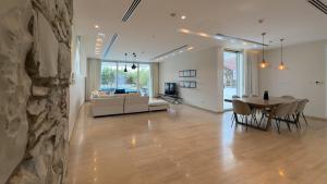 a living room and dining room with a stone wall at Vivo Mare Beachfront Villas - Seashell in Ayia Napa