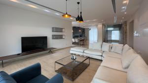 a living room with a white couch and a tv at Vivo Mare Beachfront Villas - Seashell in Ayia Napa