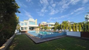 a backyard with a swimming pool and a house at Vivo Mare Beachfront Villas - Seashell in Ayia Napa