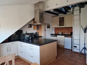 a kitchen with white cabinets and black counter tops at Himmelreich Nahne in Osnabrück