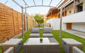a patio with two chairs and a table in the grass at Panos Relaxation Villa in Souvala