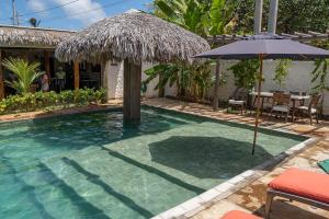 阿廷斯Vila Mani Atins Casa com Piscina的一个带遮阳伞和桌椅的游泳池