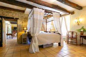 una camera da letto con un letto a baldacchino di La Maison Louverie a Pontours Altre 49 foto
