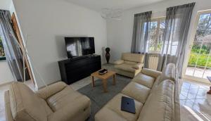 a living room with a couch and a tv at Villa Fabiani in Fonte Nuova