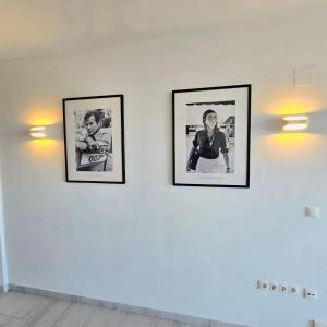 three framed pictures on a white wall with lights at Marbella city center appartment walking distance beach and plaza de los naranjos in Marbella