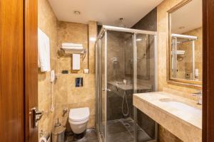 a bathroom with a shower and a toilet and a sink at Crestium Taksim Prive & Spa in Istanbul