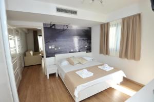 a bedroom with a white bed with two towels on it at Villa Tomislav 2 in Brela +60 photos