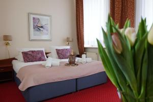 チェンストホヴァにあるHotel Sonexのベッドと花瓶のあるホテルの部屋