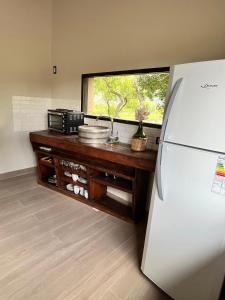 a kitchen with a refrigerator and a counter with a window at Tulma Cabañas in Volcán