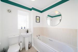 a bathroom with a tub and a toilet and a sink at Ideal 3 bed House in Wolverhampton - Parking in Wolverhampton +12 photos