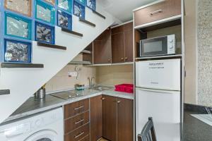 a kitchen with a refrigerator and a microwave at Dunaflor Gemelo 3 in San Bartolomé de Tirajana