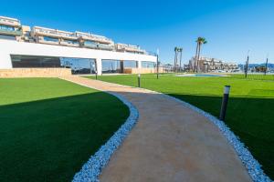 une passerelle devant un bâtiment avec une pelouse dans l'établissement BENIDORM Amber Stay, à Finestrat