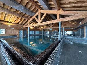 an indoor swimming pool in a building with a wooden ceiling at Chalet Hotel L’Ecrin in Tignes