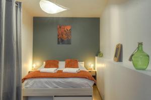 a bedroom with a bed with two pillows on it at Le Rempart, Appartement Proche Lyon & Villefranche in Anse