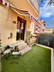 una casa con un patio con césped verde en Solemar apartments Kennedy, en Alghero