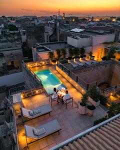 a rooftop patio with a swimming pool on top of a building at La Fiermontina Palazzo Bozzi Corso Hotel in Lecce
