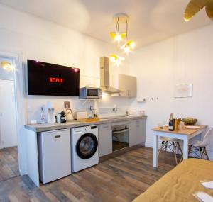 a kitchen with a washing machine and a table at Bulle Champenoise - Netflix & Wifi - Localisation Idéale - check-in 24H24 - GoodMarning in Chalons en Champagne