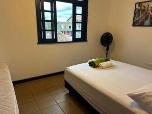 a bedroom with a bed and a window with a stuffed animal on it at Hostel Itapeva in Itapoa