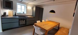 a kitchen with a wooden table and a dining room at Denkmalgeschütztes Ferienhaus in der Südeifel - Ferienhaus HAZEN in Bettingen