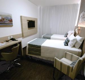 Cama ou camas em um quarto em Allia Gran Pampulha Suites