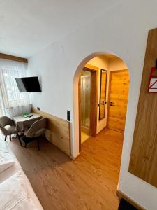 una camera da letto con arco, scrivania e letto di Pension Kristall a Flirsch