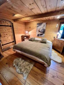 ein Schlafzimmer mit einem großen Bett in einem Blockhaus in der Unterkunft Wood chalet -Poêle à bois - proche ski et télécabine in Morillon
