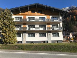 a building with balconies on the side of a street at Pension Kristall in Flirsch