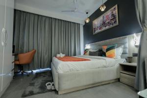 a bedroom with a large bed and a desk at Lux Paradise By Aurum in Noida