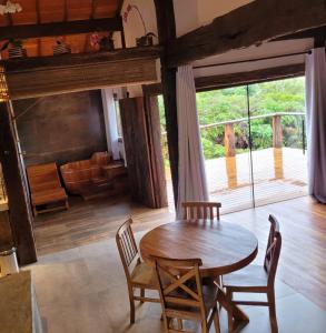 a dining room with a wooden table and chairs at Vila Santiago - Chalé Quaresmeira in Santana do Riacho