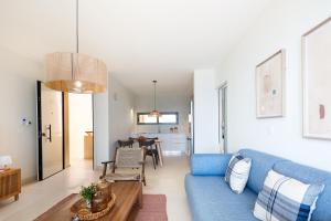 a living room with a blue couch and a table at Kalyves Coastal Retreat in Chania Town