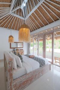 a bedroom with a large bed and some chandeliers at Bunbulan sunshine in Kubupenlokan
