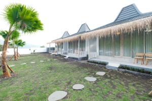 a house with a yard next to a palm tree at Bunbulan sunshine in Kubupenlokan