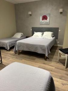 a room with two beds and a chair in it at Hôtel Restaurant Les Chasseurs in Marine de Pietracorbara +44 photos