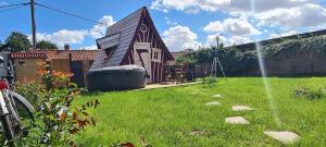 a small house in a yard with a green lawn at La cabane féerique in Ames