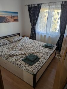 una camera da letto con un letto con due asciugamani sopra di Noua Apartment a Braşov Altre 19 foto