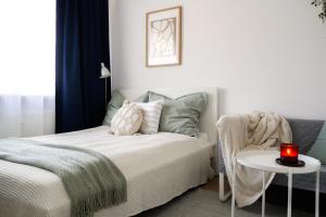 a bedroom with a bed and a table with a candle at Flamingo - Nadmorski Apartament Przy Lesie - Love & Family Apartments in Sopot