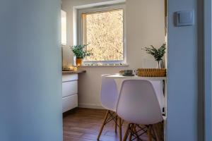 a kitchen with two chairs and a table and a window at Flamingo - Nadmorski Apartament Przy Lesie - Love & Family Apartments in Sopot