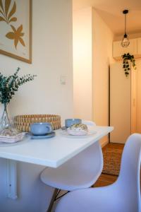 a white table with two plates and a chair at Flamingo - Nadmorski Apartament Przy Lesie - Love & Family Apartments in Sopot
