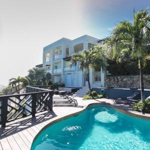 a swimming pool in front of a house at Villa en Sea in Philipsburg