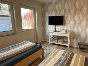 a bedroom with a bed and a flat screen tv at Apartment Schorre in Löhne