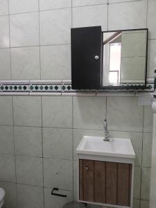 a bathroom with a sink and a mirror on the wall at Casa da vila in Imbituba