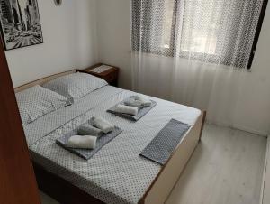 a bedroom with a bed with towels on it at Braco apartments by the sea with a sea view in Zaboric +62 photos
