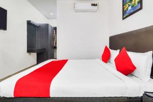 a bedroom with a large bed with red pillows at Super Hotel O Qualia Hotel Dilsukhnagar Near Dilsukhnagar Metro Station in Hyderabad +37 photos