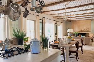 eine Küche mit Herd und Tisch in einem Zimmer in der Unterkunft Langhuis Guesthouse in Graaff-Reinet