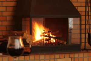 a fire in a brick fireplace with a glass of wine at HAKONE GORA ONSEN Hotel Kasansui in Hakone