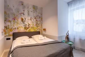 ein Schlafzimmer mit einem Bett und einem Gemälde an der Wand in der Unterkunft Apart-Invest Gimnazjalna 3 in Szklarska Poręba