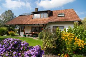 a house with a garden with flowers at Anne´s Ferienwohnung in Bad Waldsee
