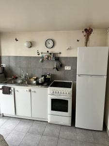 a kitchen with a white stove and a refrigerator at Petite maison calme dans un jardin in Bois-Colombes