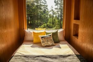a bed with pillows in a room with a window at Chalet BLOK in Lac-Beauport