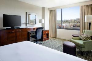 a hotel room with a bed and a desk and a television at Marriott St. Louis West in Chesterfield